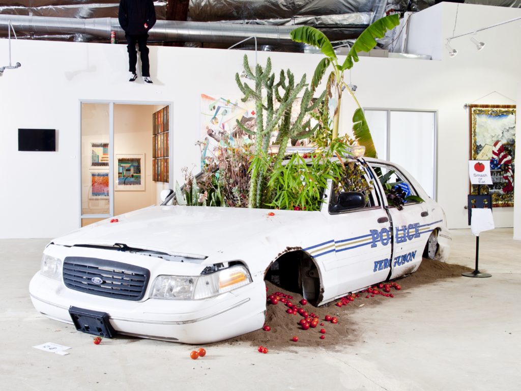 American Dreamers Phase 2 (police vehicle, earth from Ferguson, various fruit trees and plants). Image courtesy the artist.