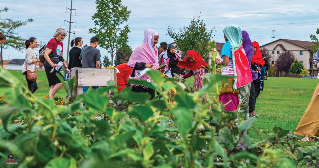 Community members tour the community garden at World Garden Commons, the pilot site of The Fargo Project, tended by Growing Together during the Welcoming Week celebrations.